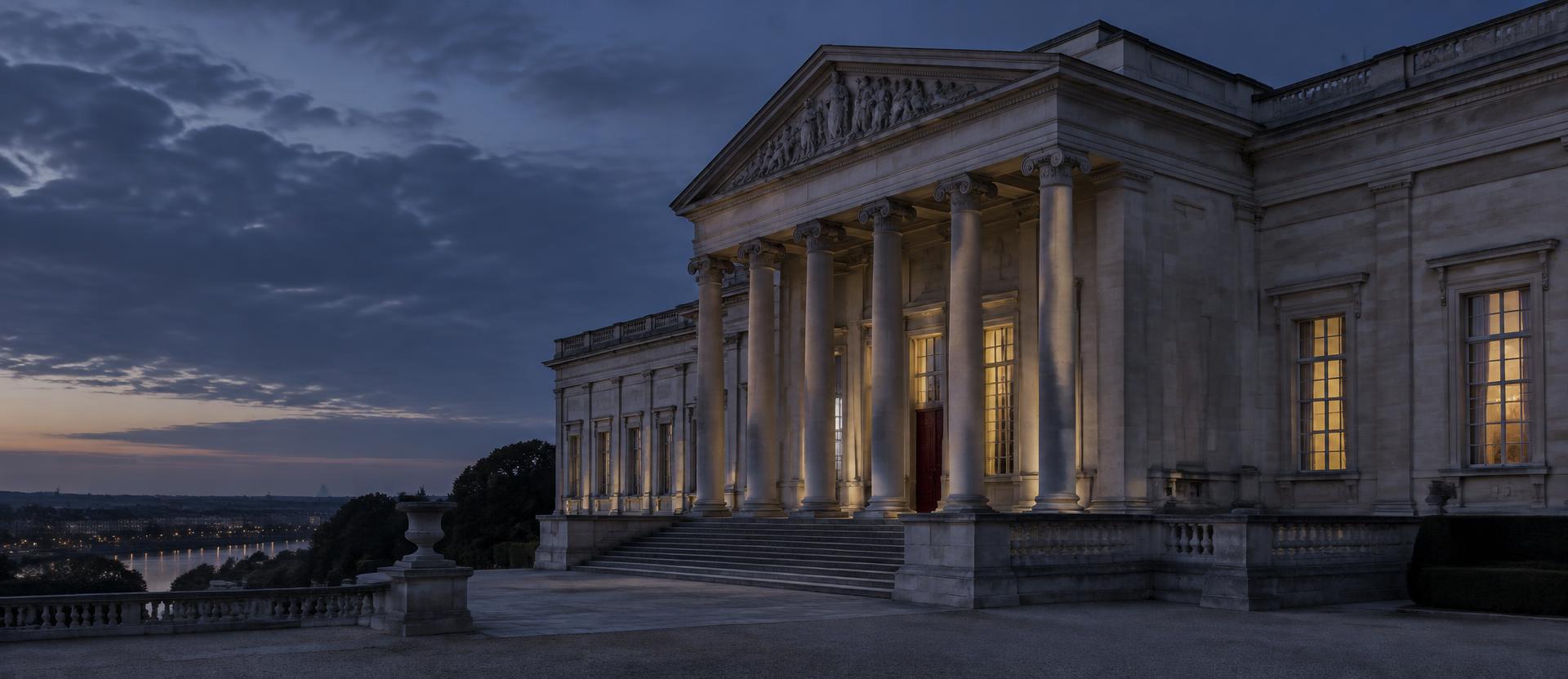 A classical stone building with columns at dusk